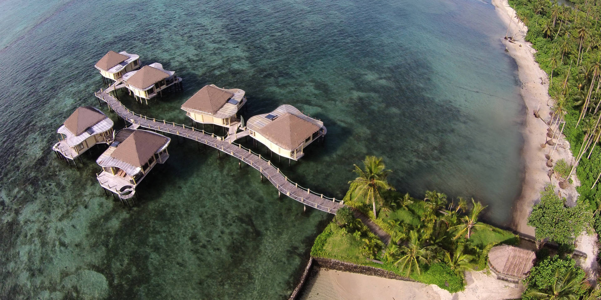 Aerial view of Coconuts Beach Club over-the-water fales and lagoon